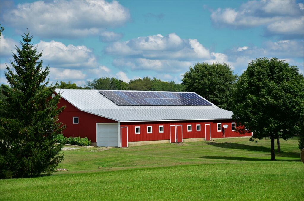 Red barn with solar panels on the roof in a rural Virginia setting representing renewable energy for commercial agriculture.